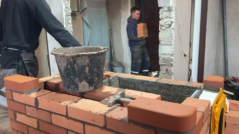 Building a heating stove, Bricklayer laying brickwork, Bricklayers assistan.. Stock Footage 321839380