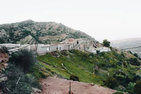 A building on a hill, overlooking the sky, trees, and mountains in Morocco Stock Photos