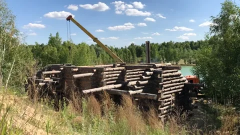 Building a house from a log. A group of men install a log house on a foundation. Stock-Footage 131863378