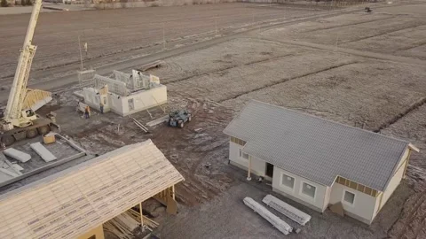 Building house in winter using large elements next to already done 4k Stock Footage 140257959