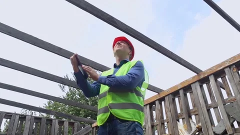 Building inspector. Man in a hard hat and a yellow reflective vest examines dama Stock Footage 205552273