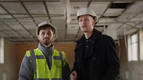 Building inspector talking to construction worker. Architect engineers in Stock Footage 236644029