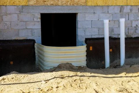 Building installation window well for basement construction on a new home 스톡 사진