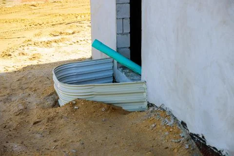 Building installation window well for basement construction on a new home 스톡 사진