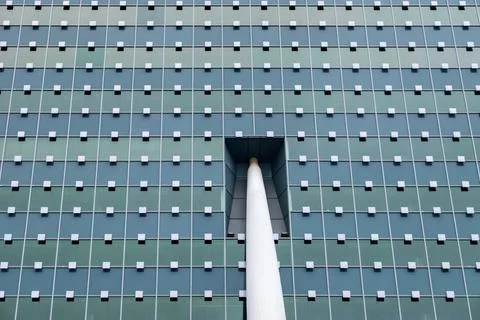A building with a large window and a white pole sticking out of it Foto stock