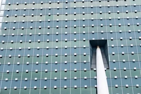 A building with a large window and a white pole sticking out of it Фото