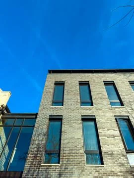 Building with large windows under clear blue sky taken during day showing m.. Stock Photos