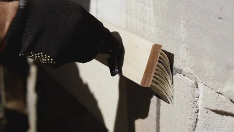 Building. A man paints a wall for insulation and plaster.. Stock Footage 121271908