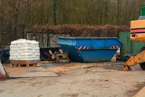 Building materials and objects on a construction site. Blue container an e... Stock Photos