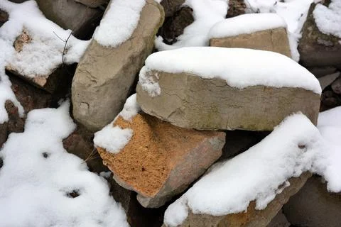 Building materials, bricks, cement blocks, metal fittings with snow in winter. Stock Photos