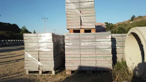 Building materials in packages, pallets stored in field at construction site. Stock Footage 136690210