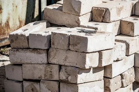 Building materials on site. Construction nails on stack of white bricks. Stock Photos