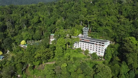 The building is in the middle of a mountain with green trees surrounding it. Video stock 173427135