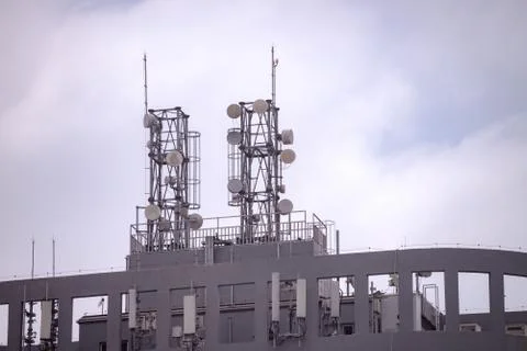 Building with mobile cellular network and microwave antenna Stock Photos