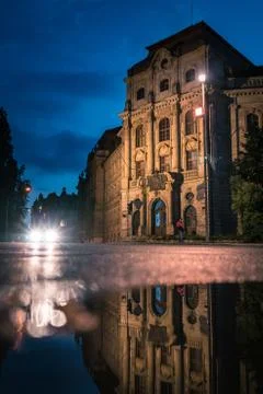 Building in the night with the reflection of a puddle. Traffic lights directly Stock-Fotos