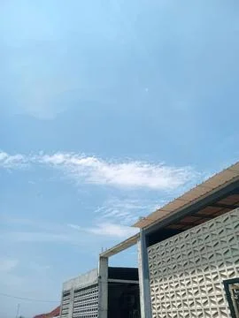 Building with patterned wall under blue sky and clouds Stock Photos