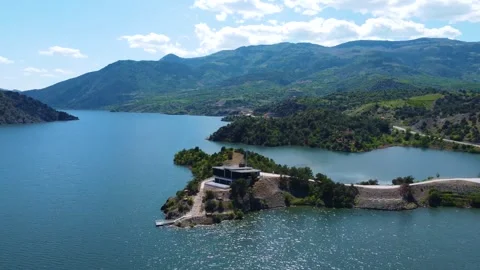 Building on a Peninsula on a Lake Between Mountains Stock Footage 247957239