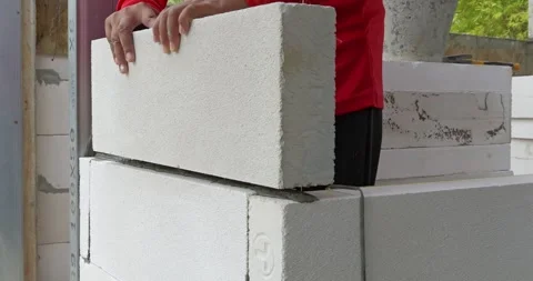 Building process in construction site demonstrating block placement techniques Stock Footage 330981195