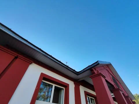A building with a red-bordered window set in a white wall, reflecting the Foto stock