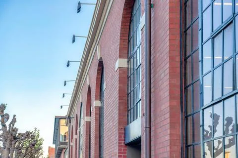 Building with red bricks and track lights across the leafless trees in San Fr Foto stock