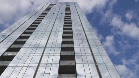 Building with reflection of clouds in blue sky - 4k Vídeos de archivo 111133210
