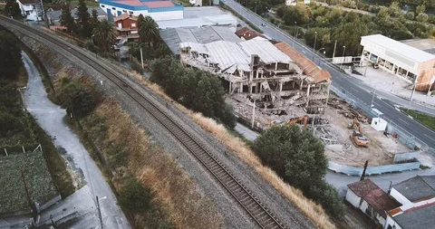 BUILDING IN RUINS BETWEEN TRAIN RAIL AND ROAD Stock Footage 91631848