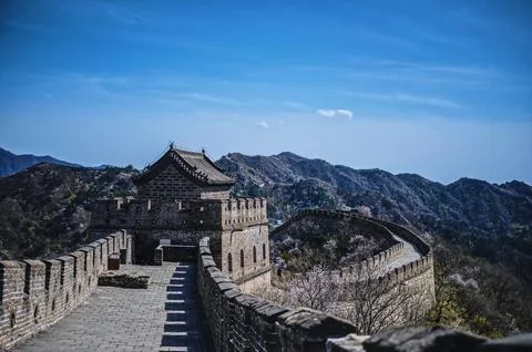 A building on the side of a large stone wall next to a steep slope Foto stock