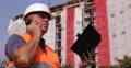Building Site Chief Verify Clipboard Plans Use Cell Talking Structure Details 4k or 4k+ Resolution