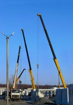 Building site with a crane trucks that unloads trucks and works on constructi Stock Photos