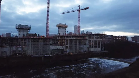 Building Site by River with Cranes at Dawn Stock Footage 128823509