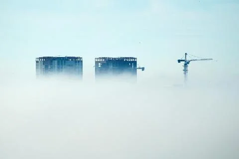 Building a skyscraper high in the clouds with the crane Stock Photos