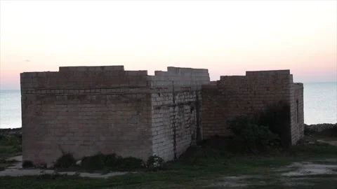 Building on small island in water ocean off coast at sunset sunrise close up Video stock 252153451