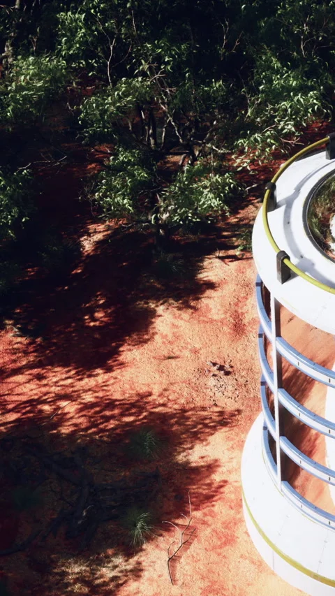 Building stands in a natural area with greenery and red ground Stock Footage 341257545