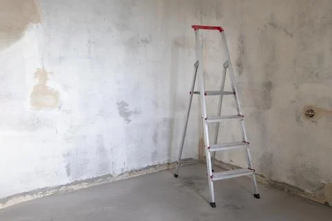 Building stepladder stands in empty room Stock Photos