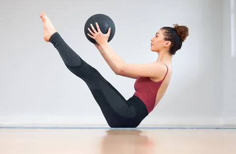 Building a stronger core one rep at a time. a young woman doing core exercises Stock Photos