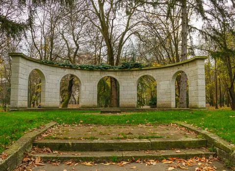 Building structure with arches in a park surrounded by trees during autumn .. Stock Photos
