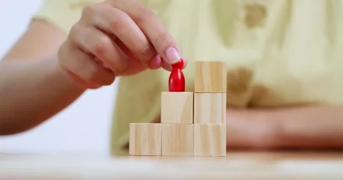 Building success a person adding to a stack of blocks a home office environment 動画素材 312928888