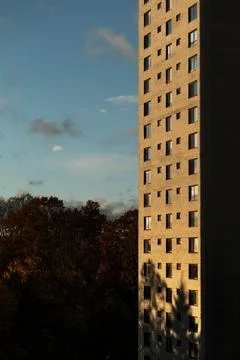 Building in sunset rays with blue sky in the background on a summer evening Stock Photos