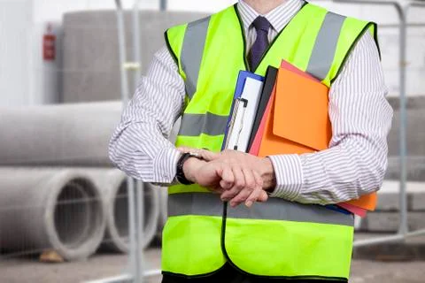 Building surveyor in high visibility checking the time on site Stock Photos