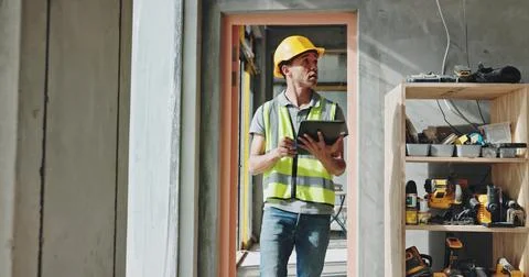 Building, tablet and walking with construction worker man on site for civil Fotos de archivo