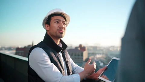 Building, tablet screen and talking with architect on rooftop for city planning Stock Footage 337924136