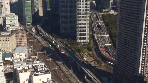 Building in Tokyo looking down on rail tracks and a busy highway Stock Footage 87341597