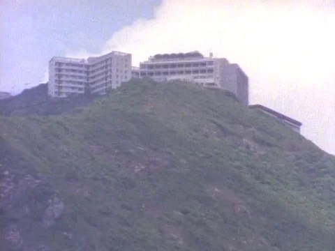 Building on top of the mountain and settlements at its base beside a busy harbor Stock Footage 79879018