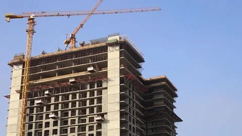 Building under construction and construction cranes on blue sky background. Stock Footage 150417755