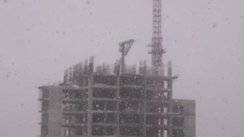 Building under construction in the back when it is snowing Stock Footage 148423683