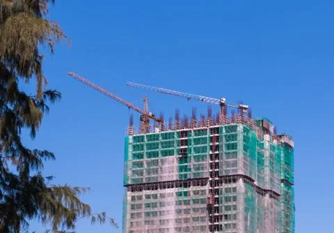 Building under construction, blue sky and tree Stock Photos
