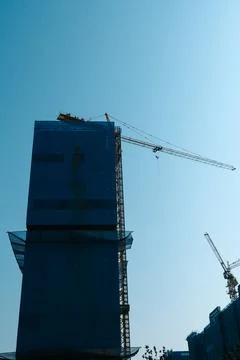 Building under construction with cranes and blue sky Stock Photos
