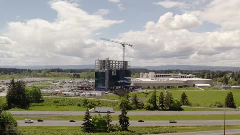 Building under construction next to freeway drone shot Stock Footage 193167115