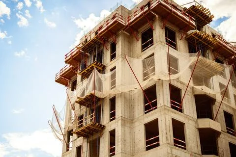 A building under construction with a protective net against falling objects f Stock Photos