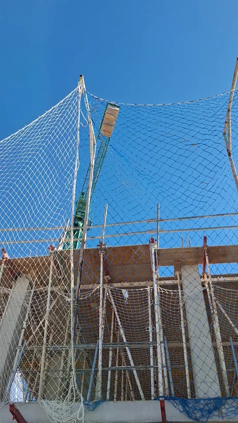 Building under construction with scaffolding and safety net in bright blue .. Stock Footage 337345061
